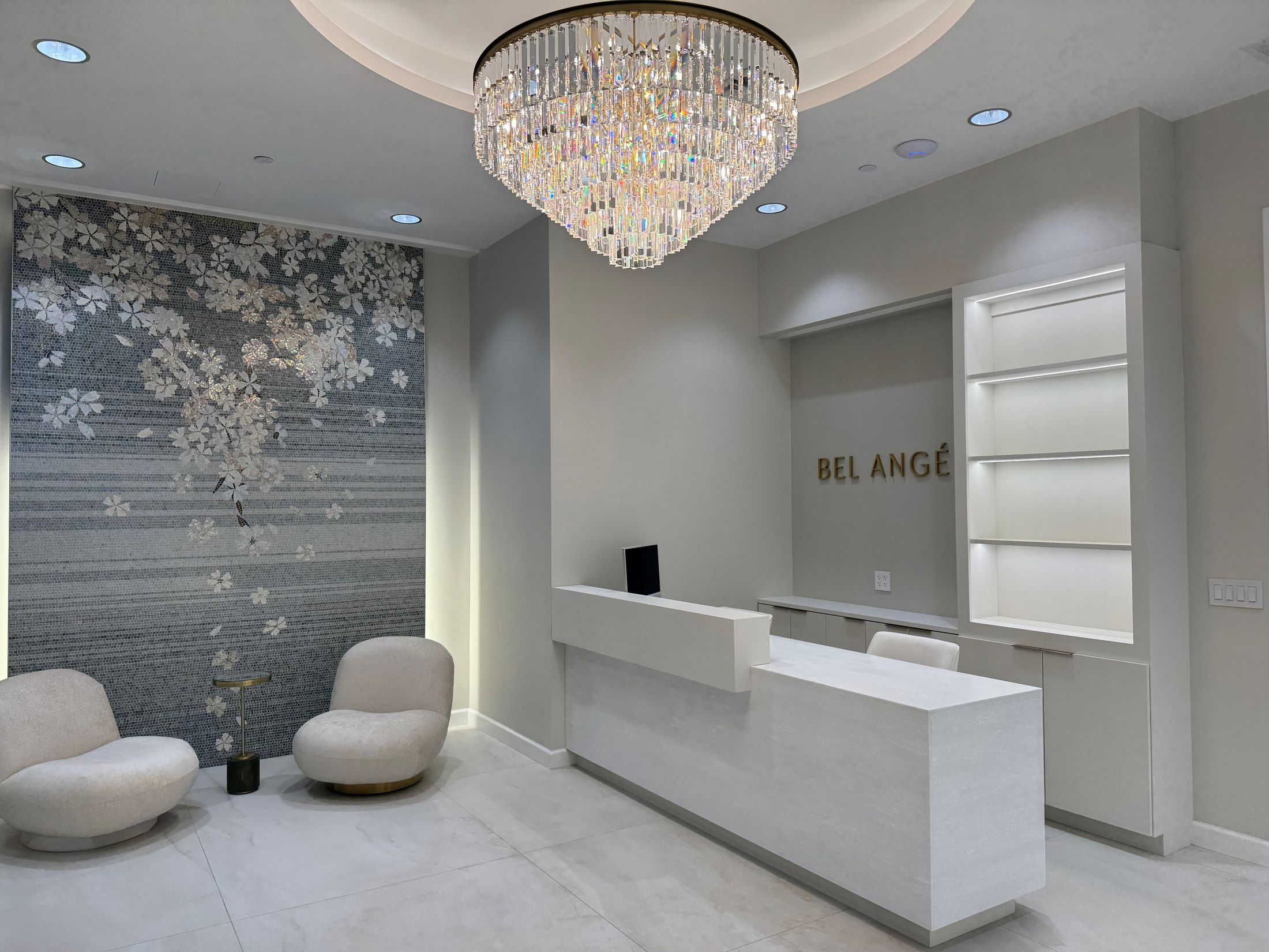 Modern reception area with elegant chandelier and decor.